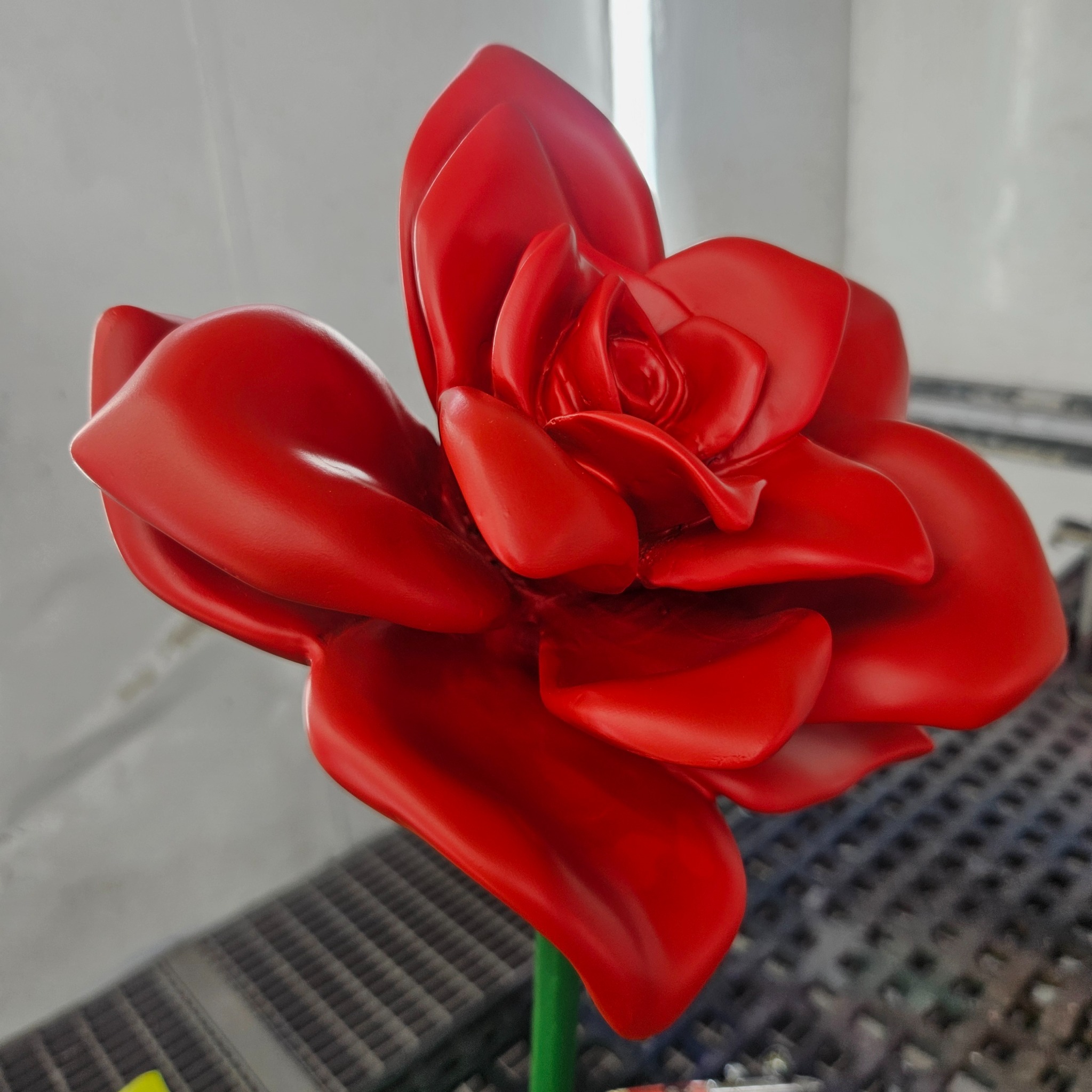 Red sculpted flower photographed during production in the studio
